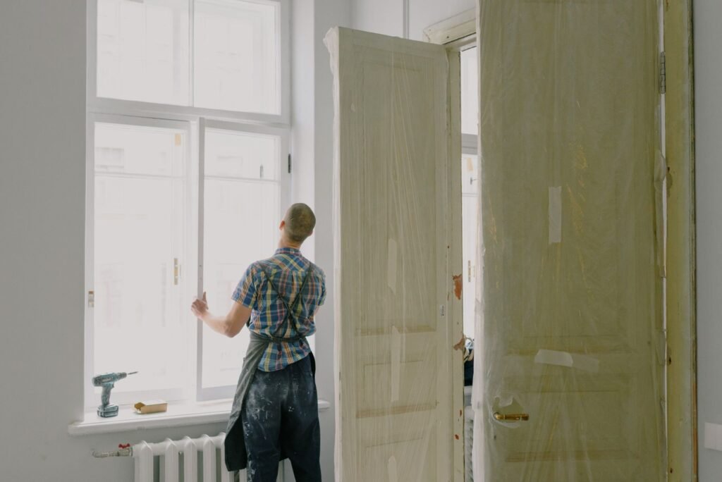 Budget des travaux : artisan posant un châssis dans un appartement