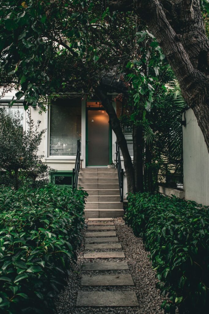 Adaptation de maison : entrée entourée de verdure
