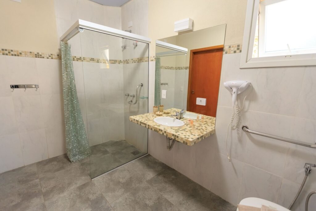Salle de bain PMR spacieuse avec grande douche vitrée