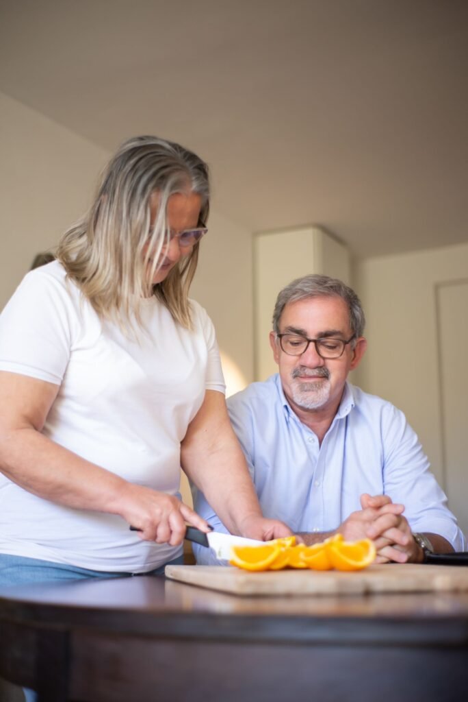 Adaptation du logement pour seniors : couple préparant des oranges dans sa cuisine