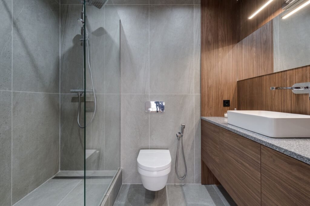 WC PMR dans une salle d’eau moderne avec douche et lavabo
